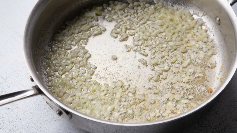 melted butter and onions in a metal frying pan