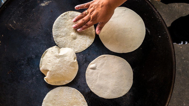 Tortillas are roasted on a traditional comal griddle