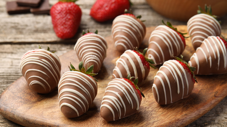 Chocolate covered strawberries on wooden board