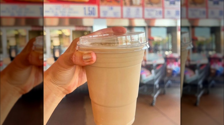 Hand holding Costco cold brew latte freeze by food court