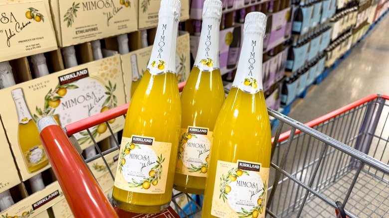 three bottles of Kirkland Signature mimosas in a Costco shopping cart