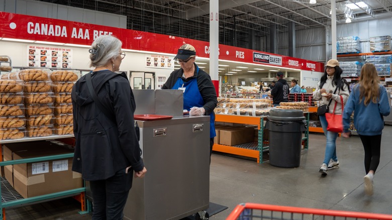 a customer stands before a sample counter at Costco