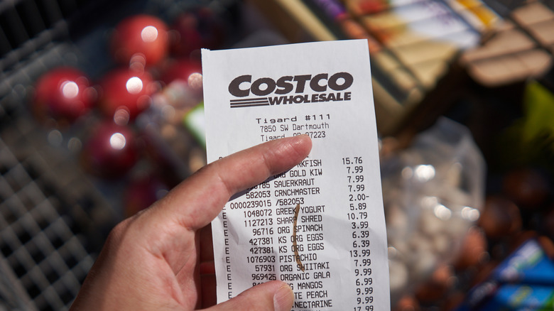 Costco shopper checking prices on receipt