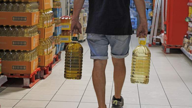 Person buying large bottles of cooking oil