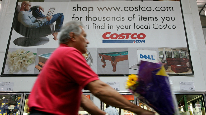 Costco worker pushing shopping cart