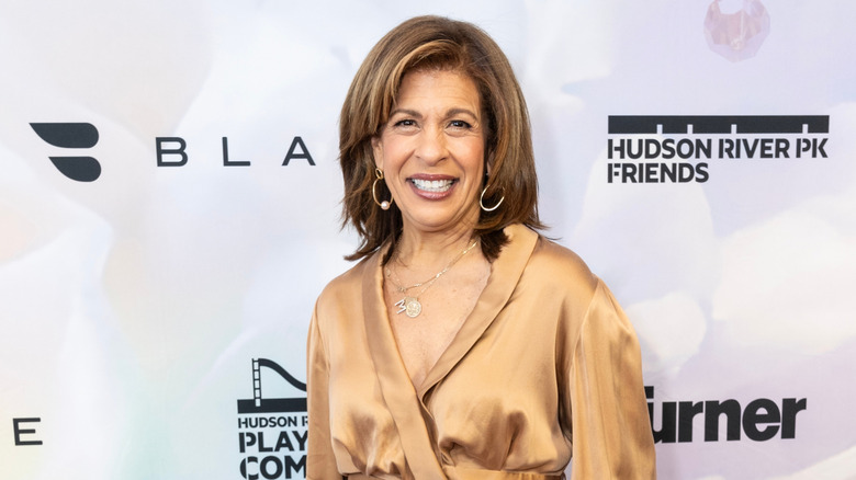 Hoda Kotb smiling at a charity luncheon red carpet.