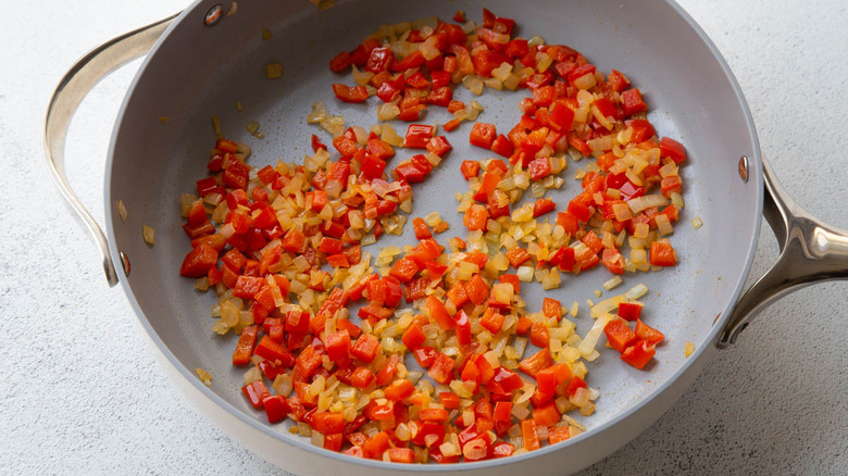 diced onion and bell pepper cooking in skillet