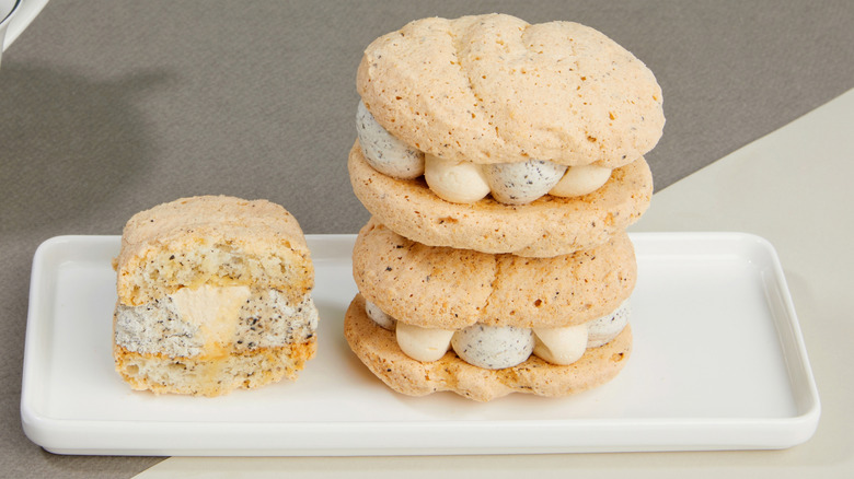 Small, individual dacquoise cakes on a rectangular white plate