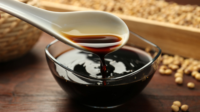 soy sauce being poured from spoon into bowl