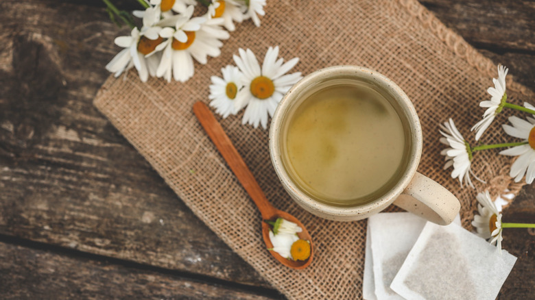 Herbal chamomile tea in a bag on wooden background.