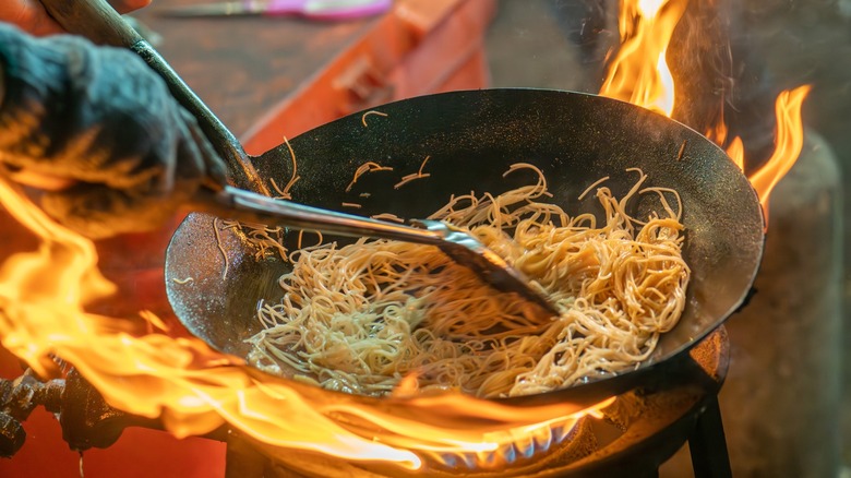 Stir-frying pad Thai in a wok