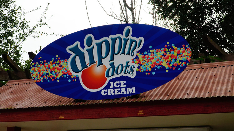 close up of two hands holding cups of Dippin' Dots