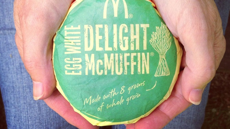 egg white delight mcmuffin in hands in wrapper