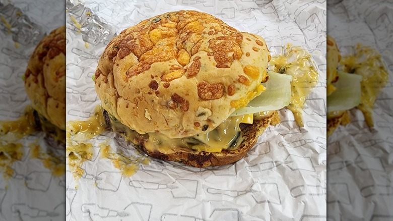 Burger with melted cheese on top on open wrapper