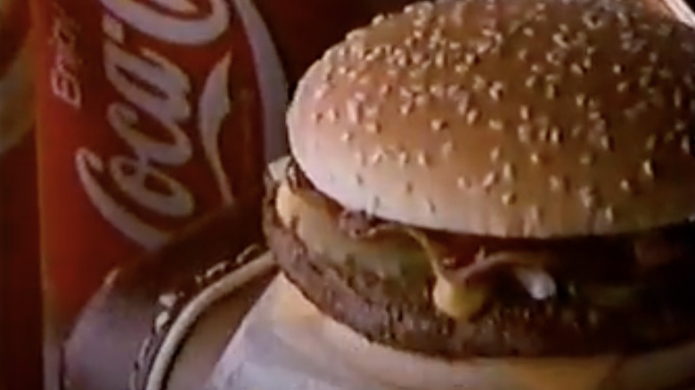 Cheeseburger next to red Coca-Cola cup