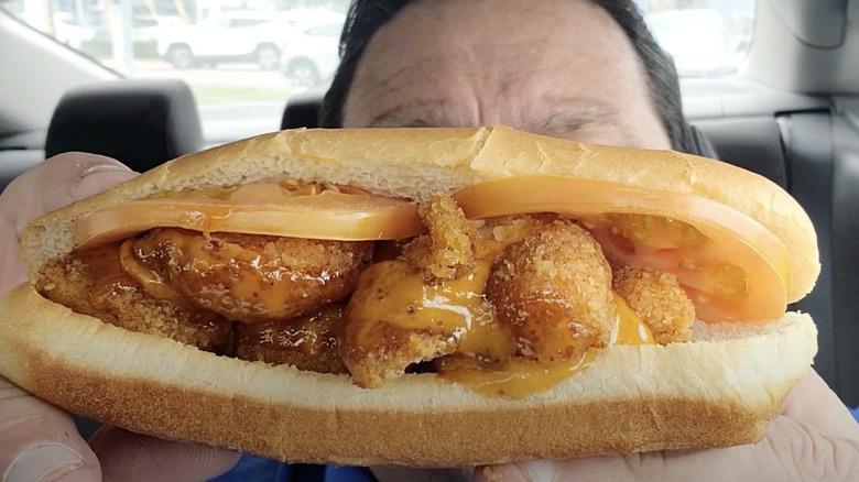 Shrimp Po' Boy from Wienerschnitzel held up by man