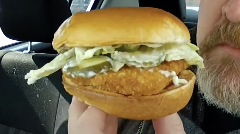 Man holding up Wendy's cod sandwich