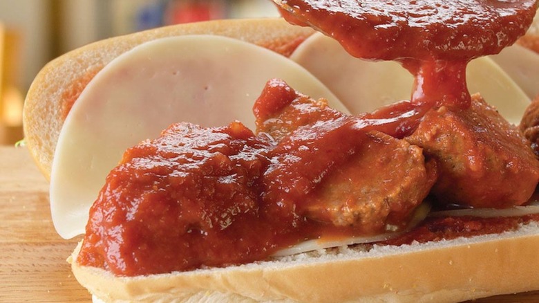 Marinara sauce being poured onto a meatball sub from Jersey Mike's