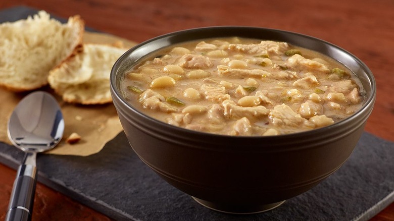 Spoon and bread next to bowl of white chicken chili