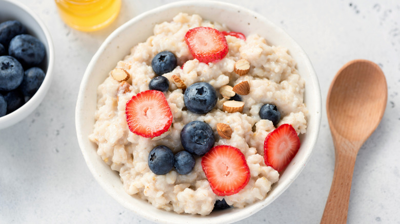 A bowl of oatmeal with berries and nuts on top