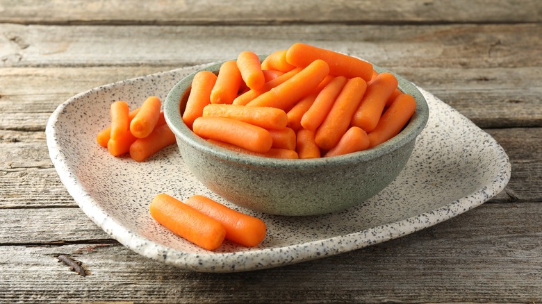 baby carrots in a bowl on a wooden table