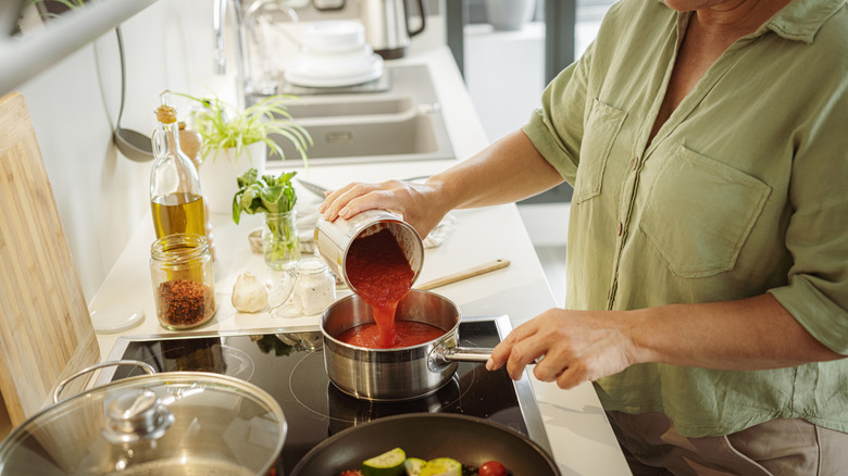 woman heating canned sauce