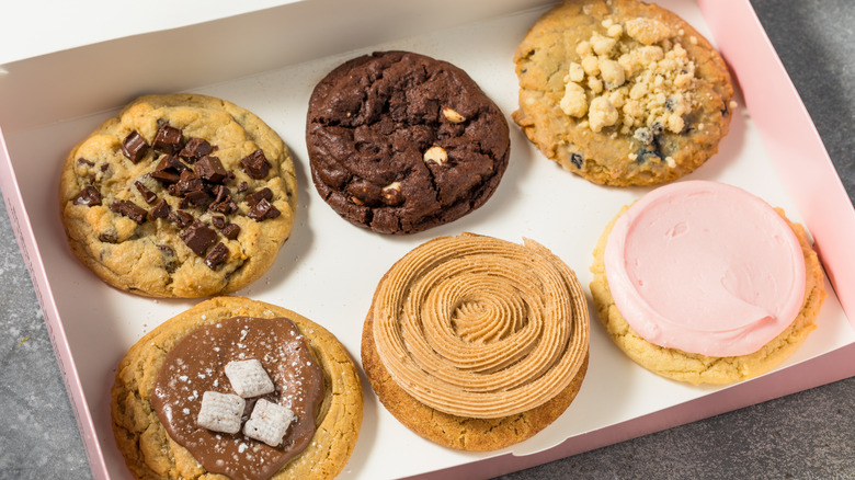 Six different kinds of Crumbl cookies together in a pink and white Crumbl box