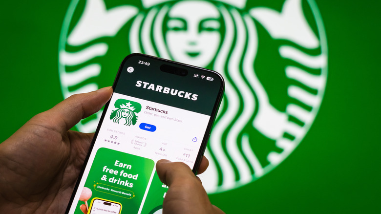 Starbucks app on phone with store logo in background