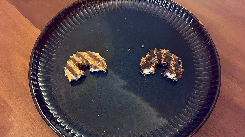 Two cookies on a blue plate on a wooden table.