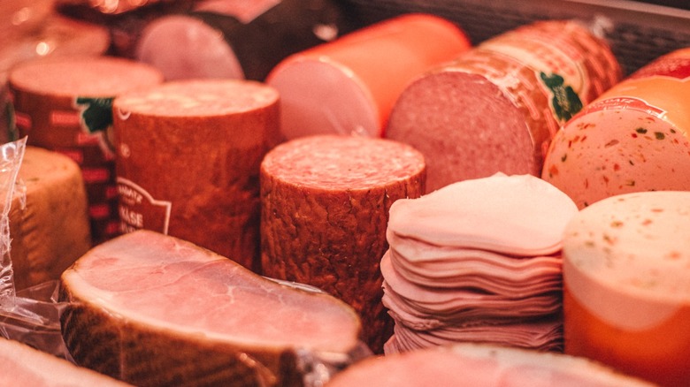 A variety of deli meats line a grocery store display case