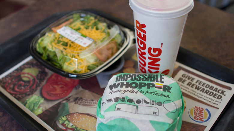 A Burger King drink and sandwich are shown with a side salad