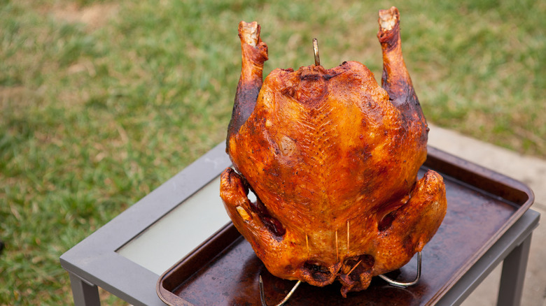 A perfectly deep-fried turkey on a metal hook