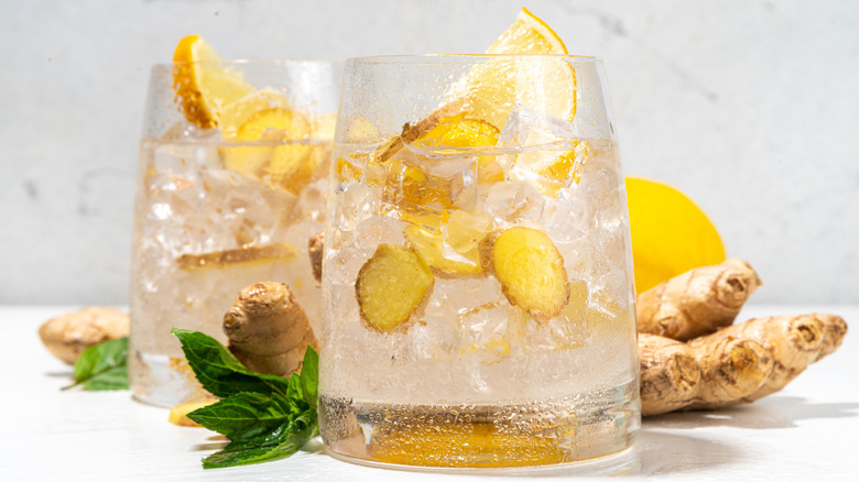 ginger ale in glass with fresh ginger and lemon