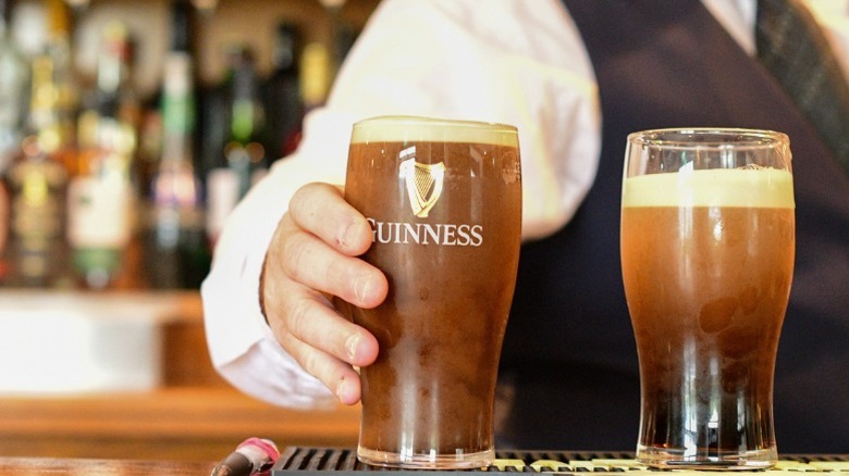 Pints of Guinness being served in an Irish pub.