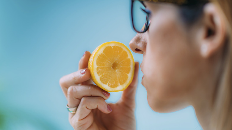 woman smelling cut lemon