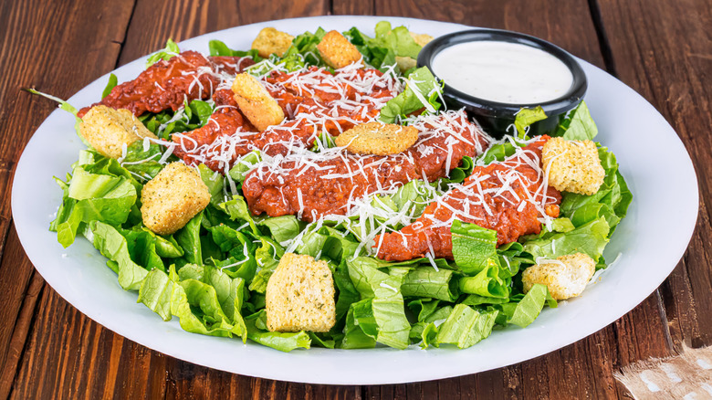 Crispy buffalo chicken strips on salad