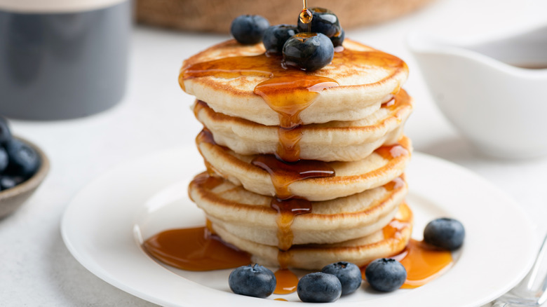 Golden thick pancakes with maple syrup and blueberries