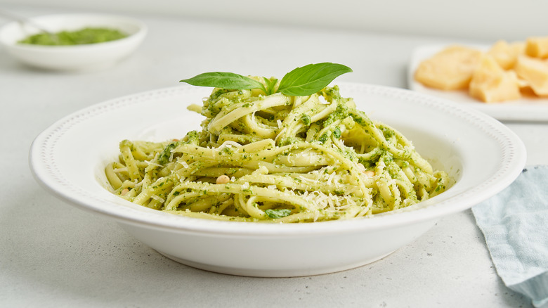 Fettuccine and pesto sauce in white bowl