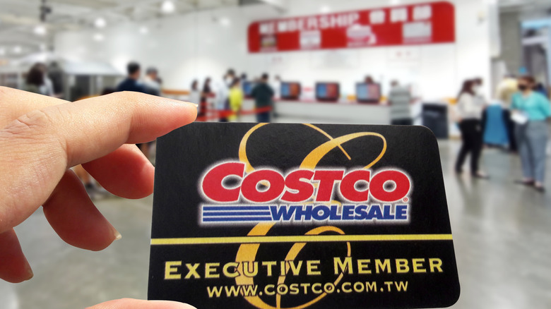 A person's hand holds a Costco card