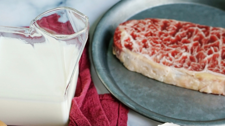 Raw steak on a plate with milk nearby