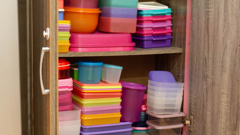 A cabinet filled with plastic containers