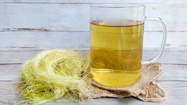 corn silk tea posed on a piece of burlap next to a pile of corn silk