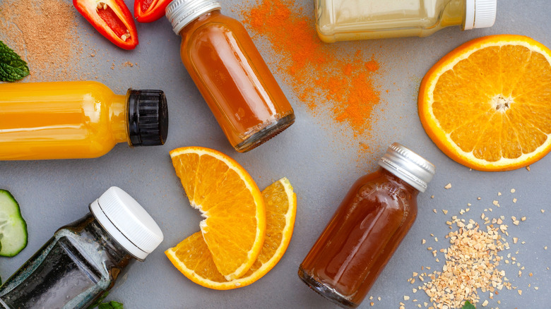 Health shots with slices of orange, cucumber, and pepper