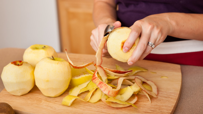 Someone peeling apples