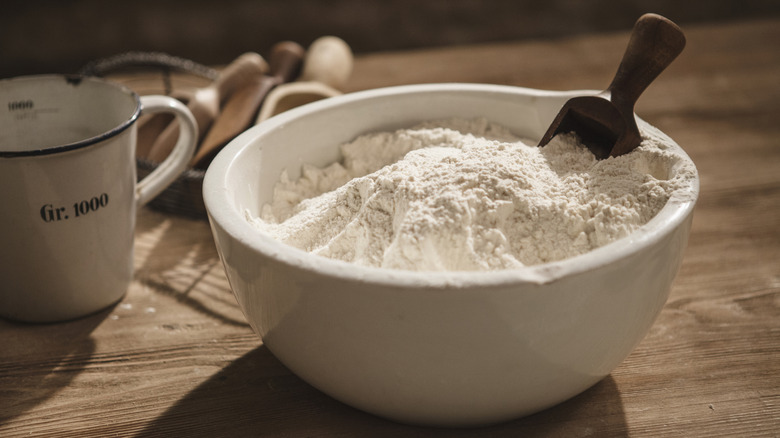 bowl of white flour on wooden table