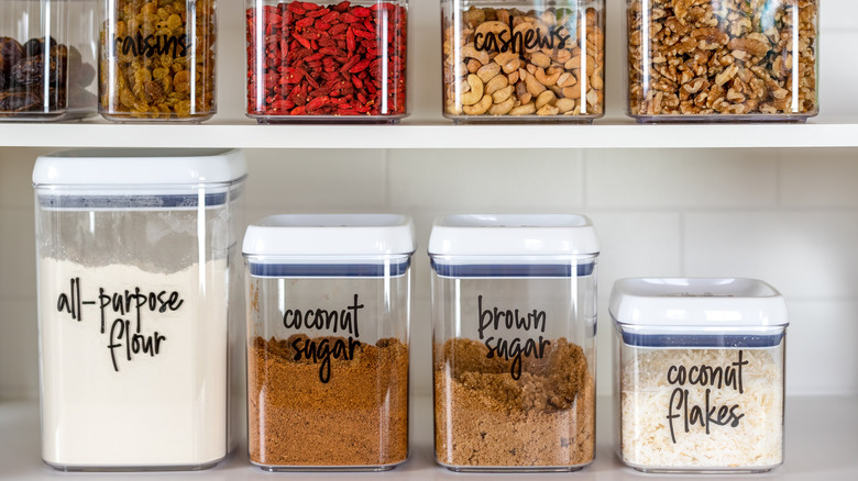 plastic containers in pantry holding pantry items like flour and sugar