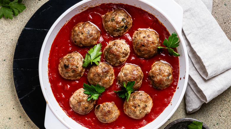 Meatballs cooked in tomato sauce with fresh herbs