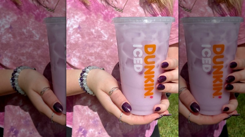 Person standing with Dunkin' coconut milk refresher