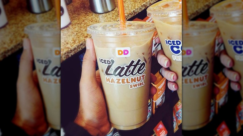 Person holding hazelnut swirl latte