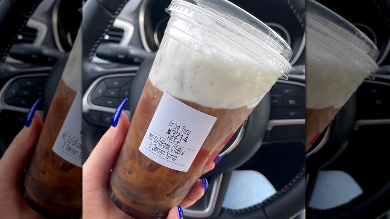 Person holding iced smoked vanilla Dunkin' drink